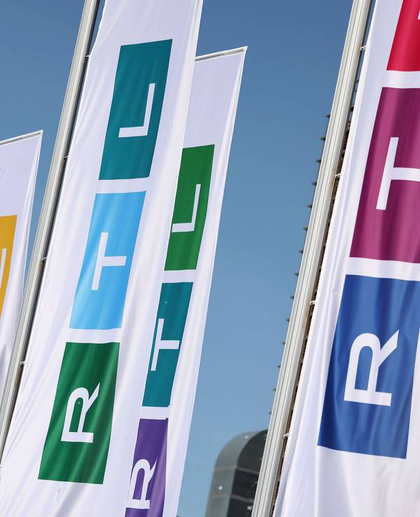 Fahnen mit dem neuen Logo des Fernsehsenders RTL wehen vor dem Gebäude.