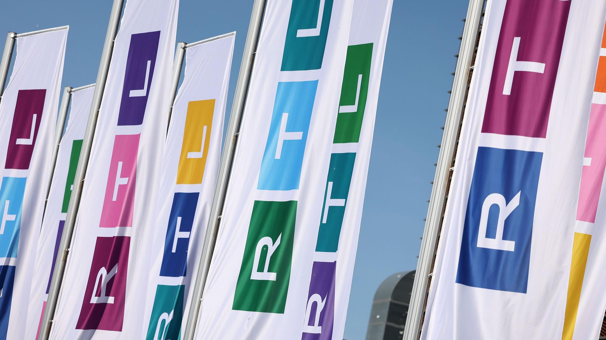 Fahnen mit dem neuen Logo des Fernsehsenders RTL wehen vor dem Gebäude.