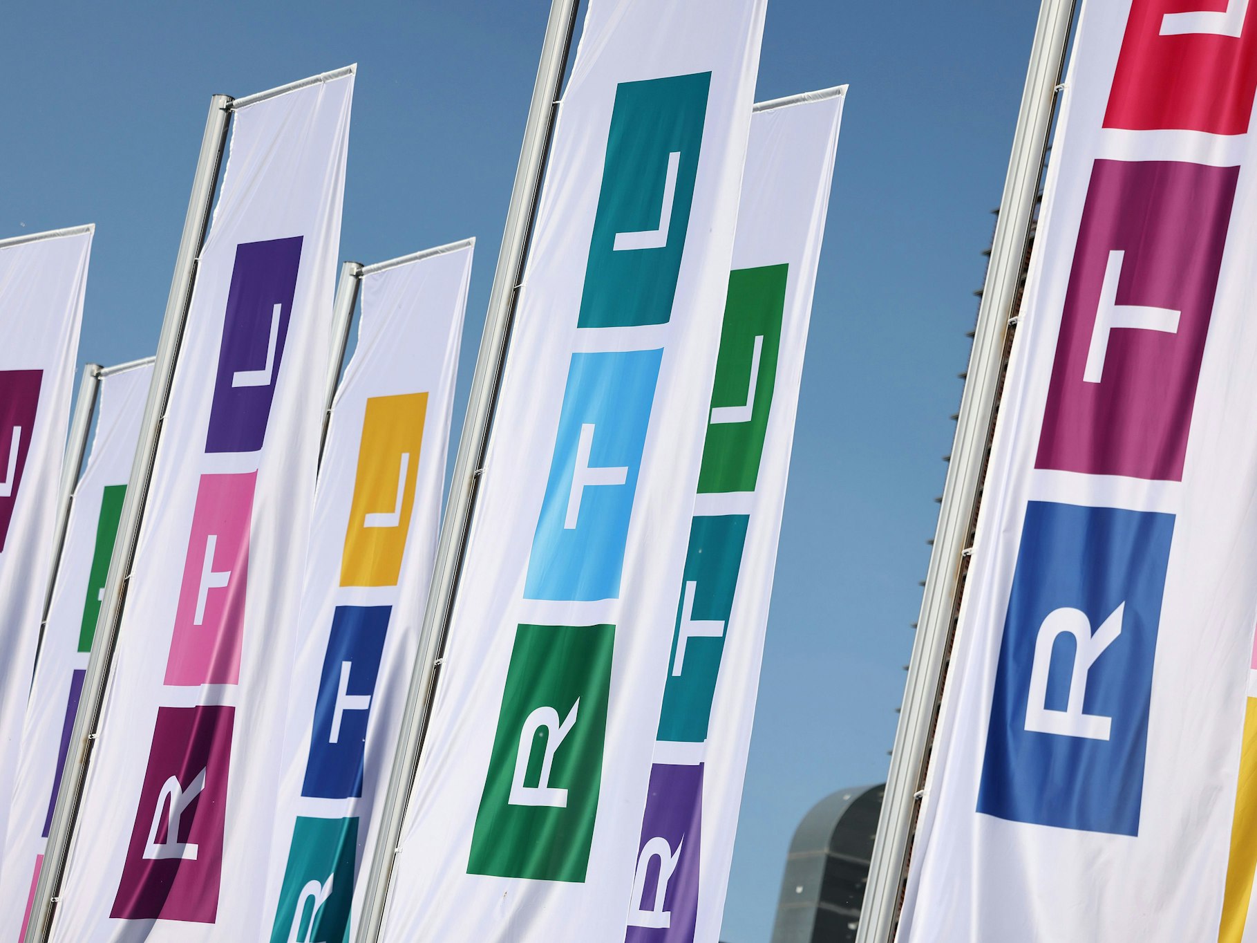 Fahnen mit dem Logo des Fernsehsenders RTL wehen vor dessen Gebäude.