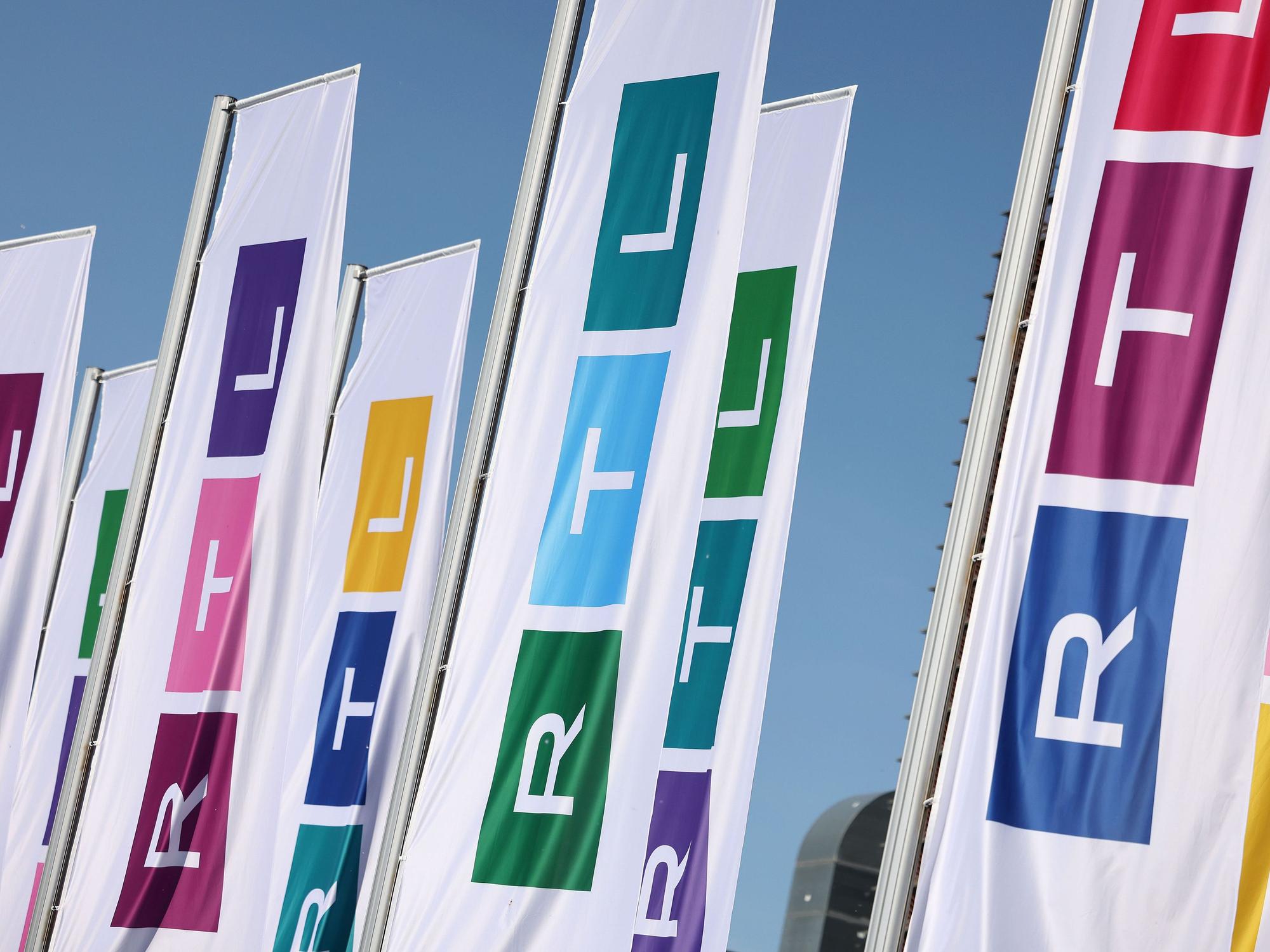 Fahnen mit dem Logo des Fernsehsenders RTL wehen vor dessen Gebäude.