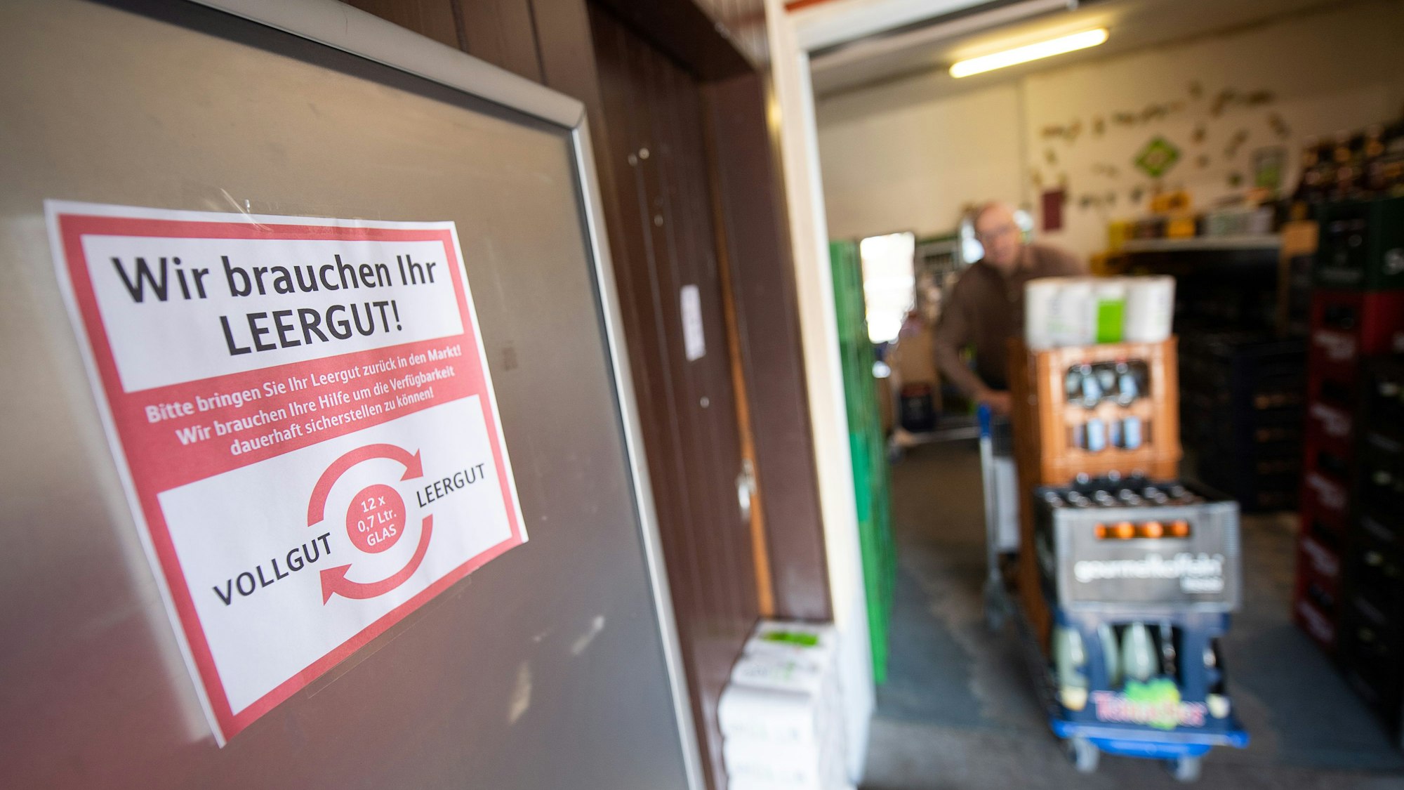Auf einem Zettel an einem Leergutautomaten steht „Wir brauchen Ihr Leergut.“