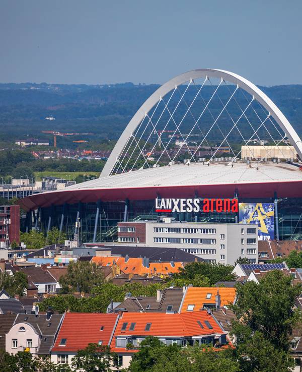 Die Lanxess Arena in Köln inmitten von Häusern.