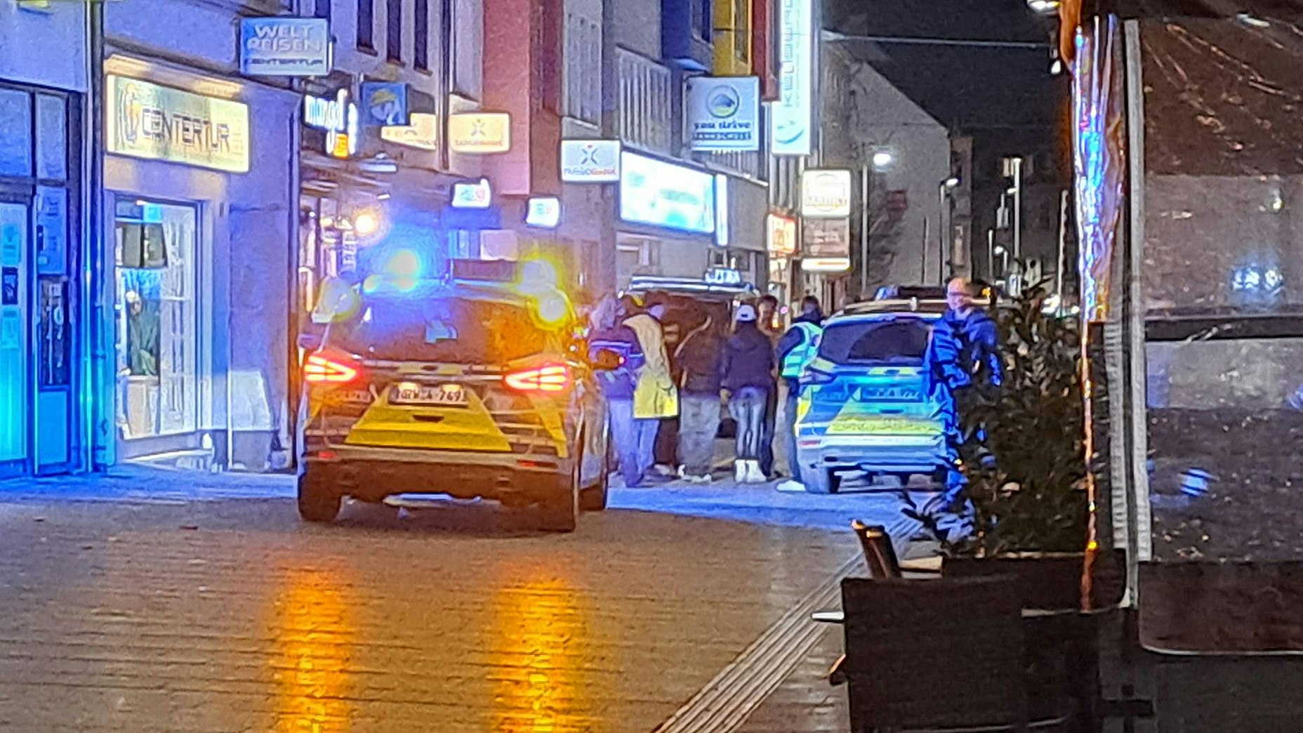Polizei-Einsatz auf der Hauptstraße in Bergisch Gladbach in der Dunkelheit.