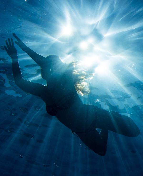 Eine Frau taucht im Wasser.