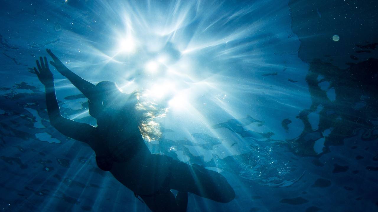 Eine Frau taucht im Wasser.