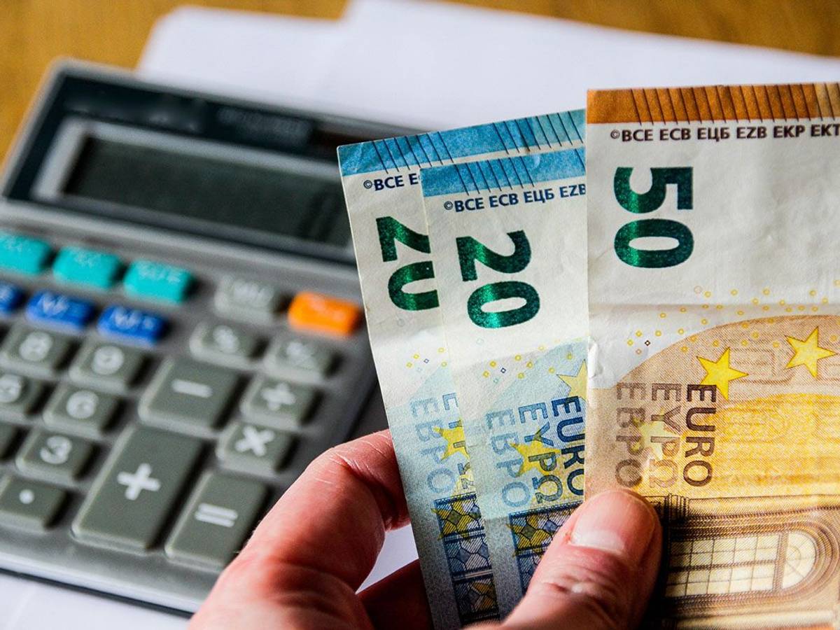 Taschenrechner und Euro-Scheine in einer Hand