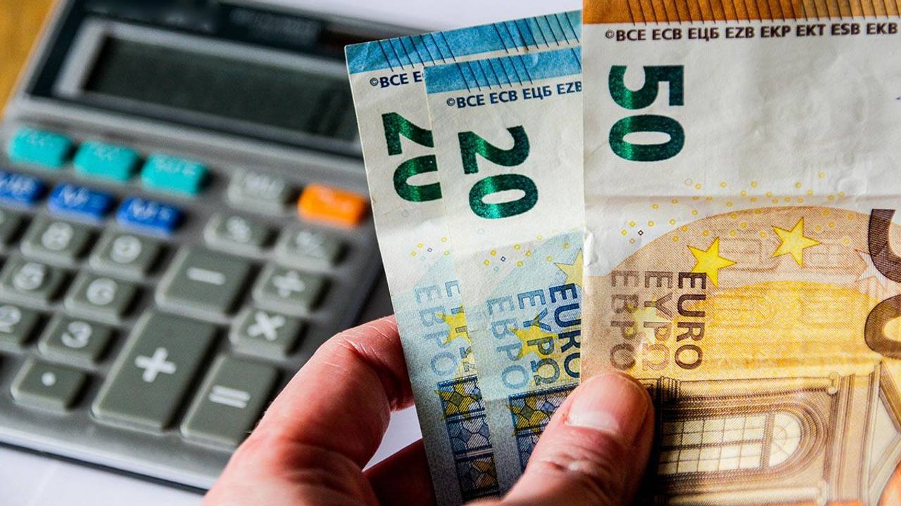 Taschenrechner und Euro-Scheine in einer Hand