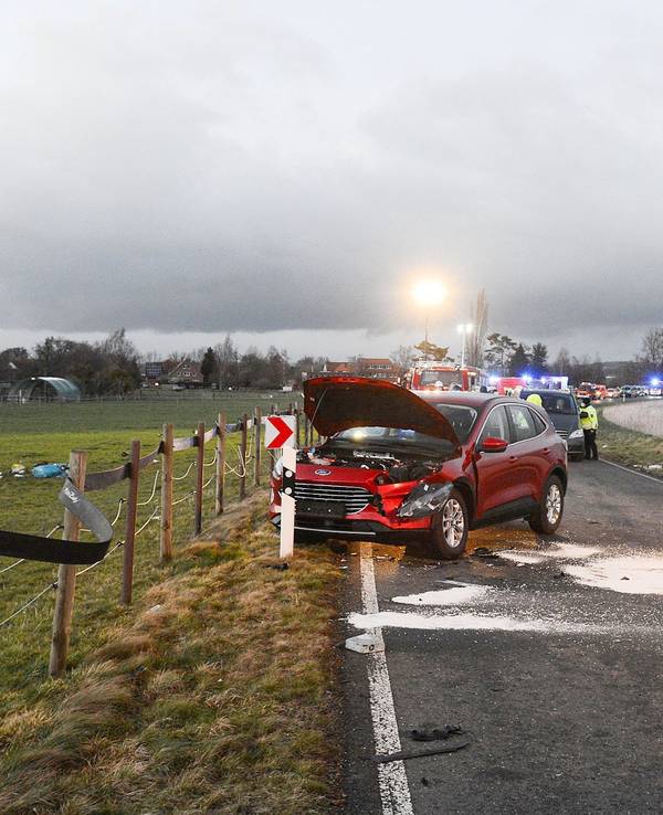Ein zerstörtes Auto (l) liegt auf einer Wiese.