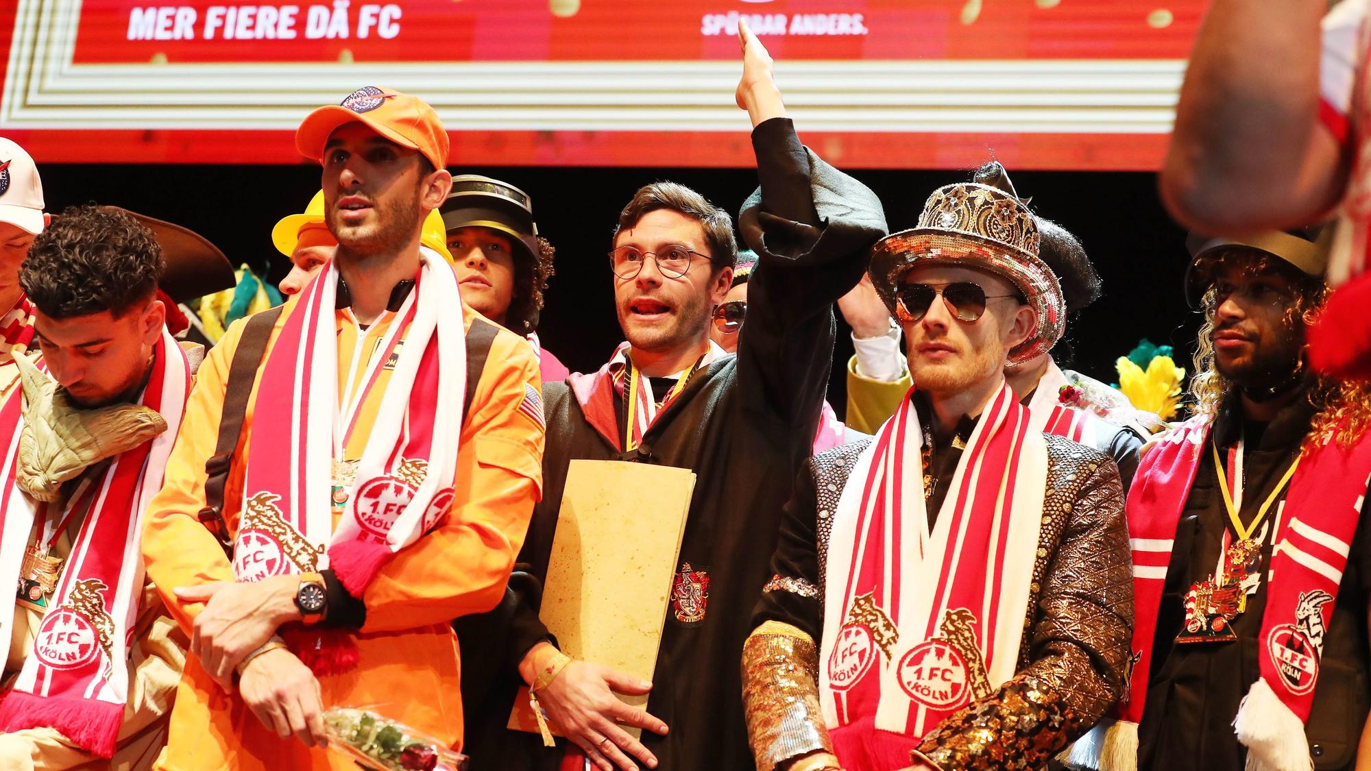 Die Profis des 1. FC Köln stehen bei der Klub-Sitzung verkleidet auf der Bühne.