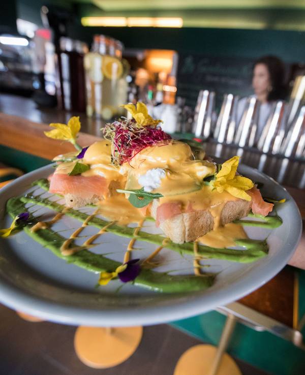 Ein Mitarbeiter des Frühstückslokals „The Gardener's Nosh“ in Stuttgart trägt im Juni 2018 während eines Fototermins einen Teller mit dem Frühstücksgericht „Benedict-Eier“, das aus pochierten Eiern, Räucherlachs, frischem Spinat und Brioche mit Beilagen besteht.