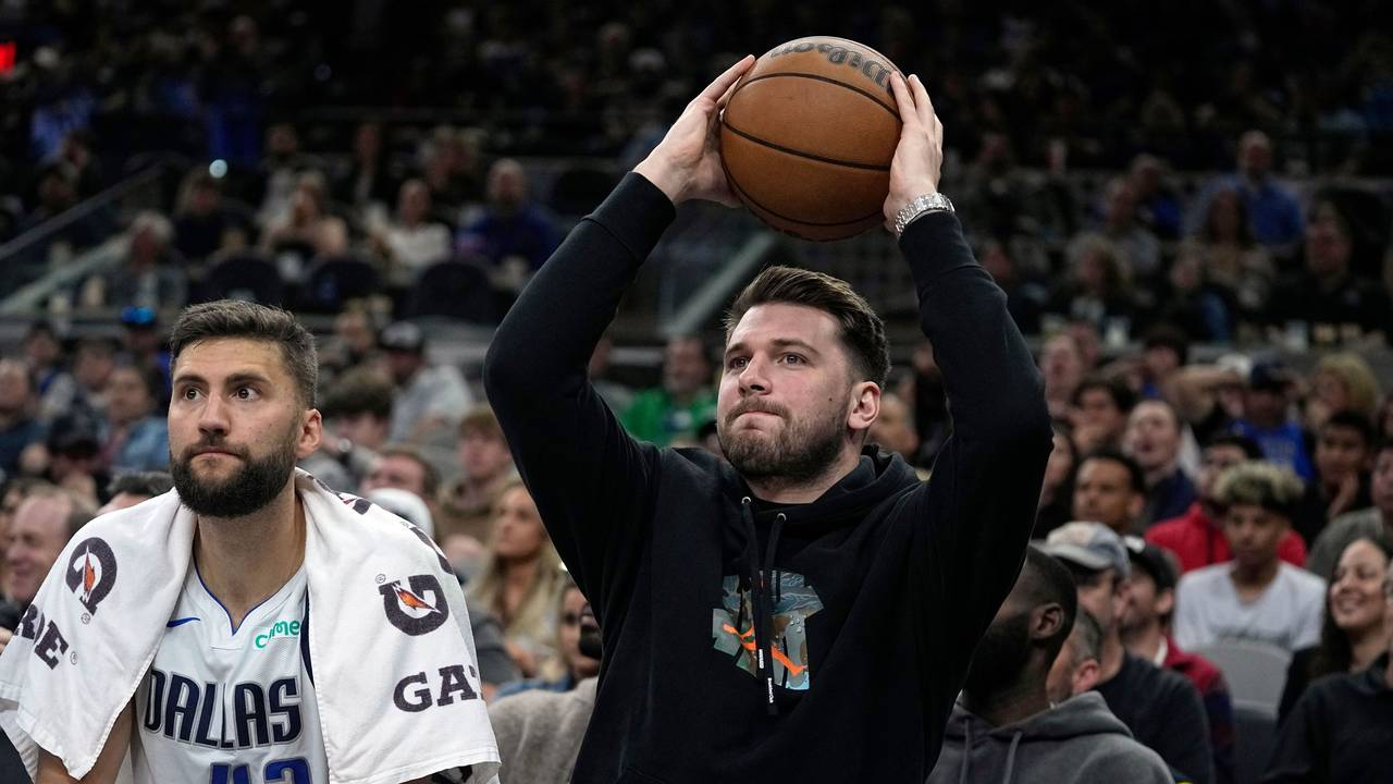 Dallas Mavericks-Guard Luka Doncic (r) gibt den Ball zurück, während er neben Maxi Kleber (42) auf der Bank sitzt.