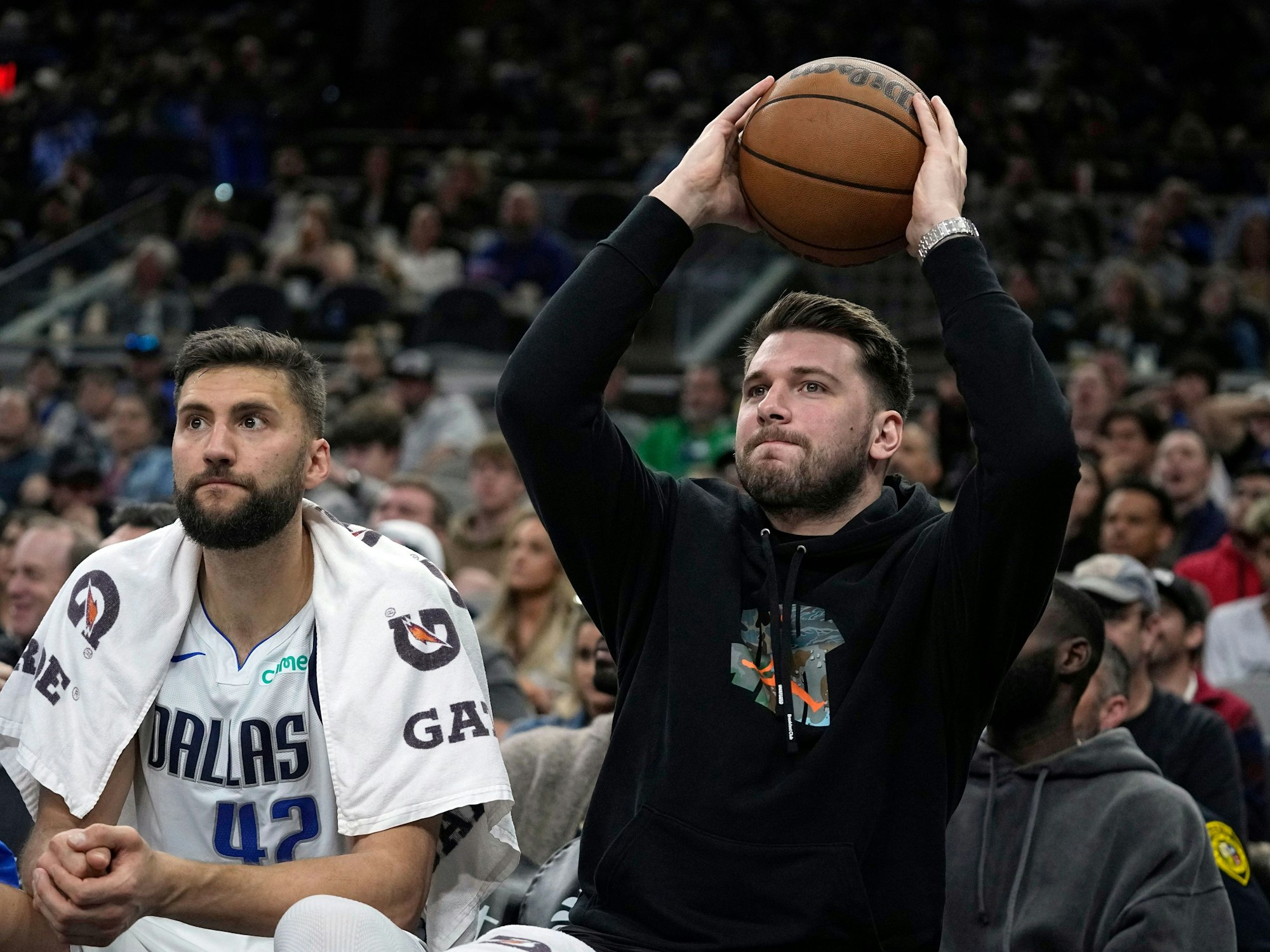 Dallas Mavericks-Guard Luka Doncic (r) gibt den Ball zurück, während er neben Maxi Kleber (42) auf der Bank sitzt.