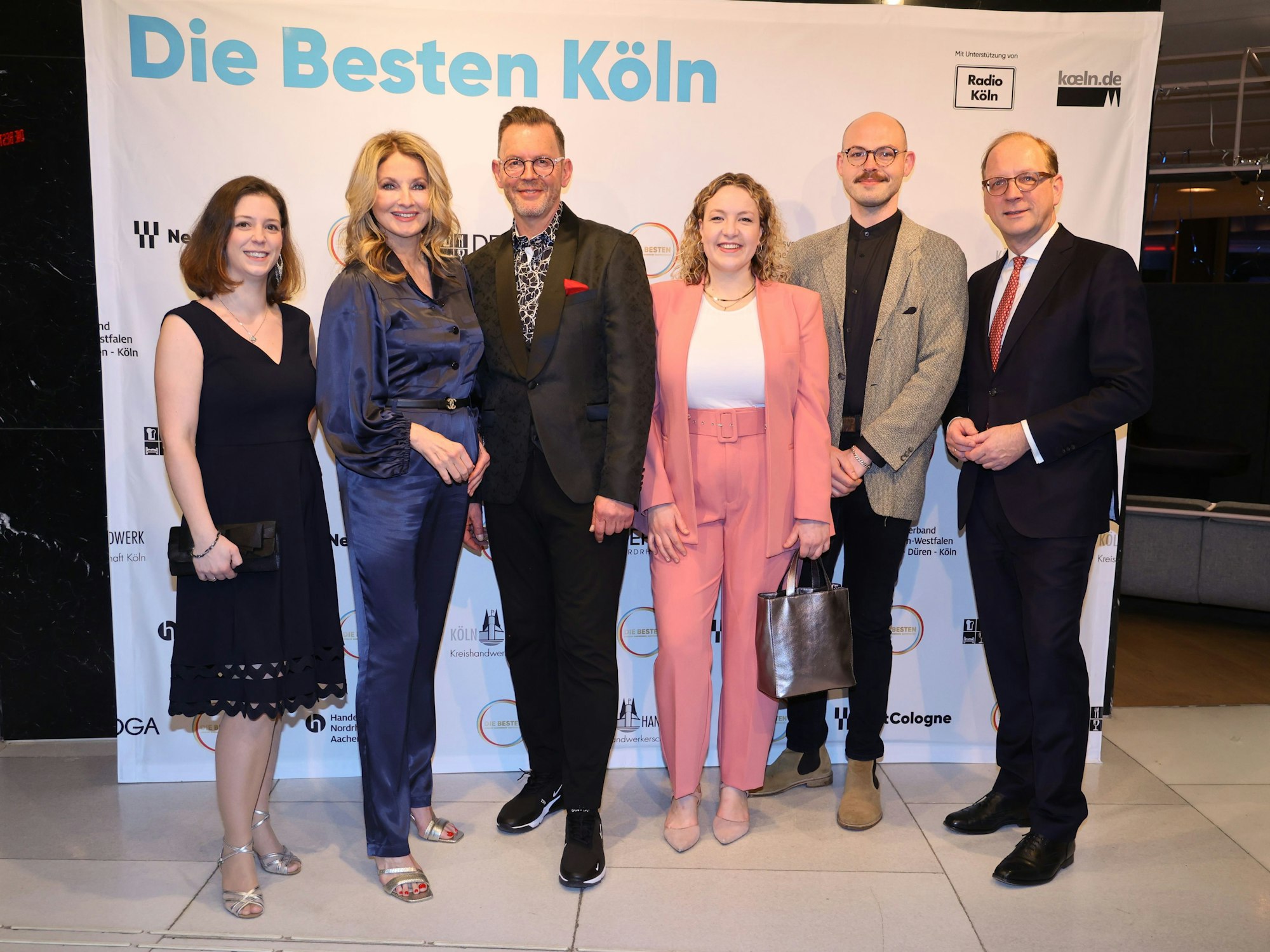 Preisverleihung Die Besten 2023: Anne Lettenbauer (Restaurant Pöttgen), Moderatorin Frauke Ludowig, Heinz-Josef Meller (Parfümerie Meller), Lea Schlosser und Kevin Thomas Kleber (Traditionscafé Osterspey) und Timo von Lepel (Geschäftsführer NetCologne).