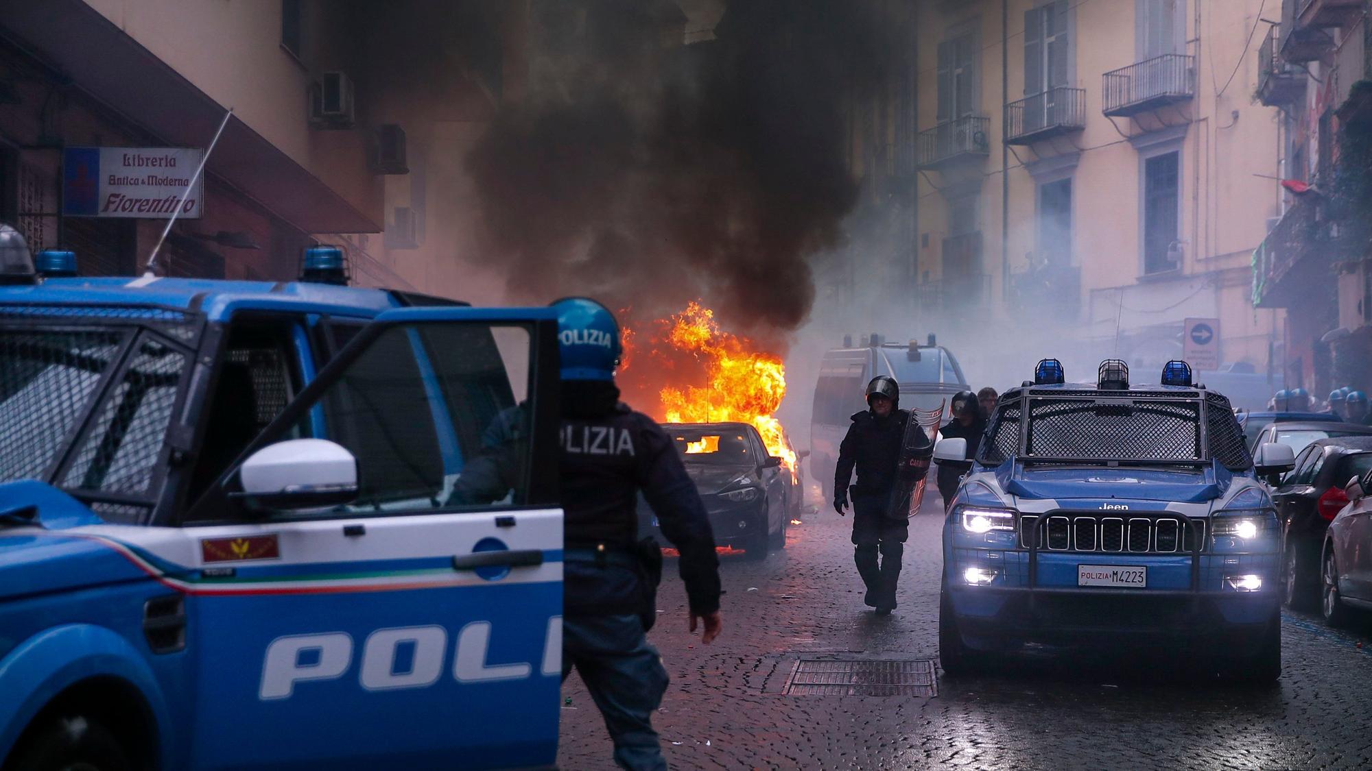 Vermummte Hooligans haben vor dem Spiel auf einer Straße ein Polizeiauto in Brand gesetzt.