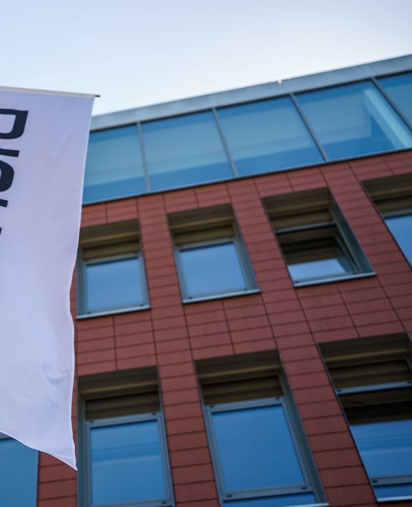 Eine weiße Fahne mit dem Schufa-Logo vor der Zentrale des Unternehmens.