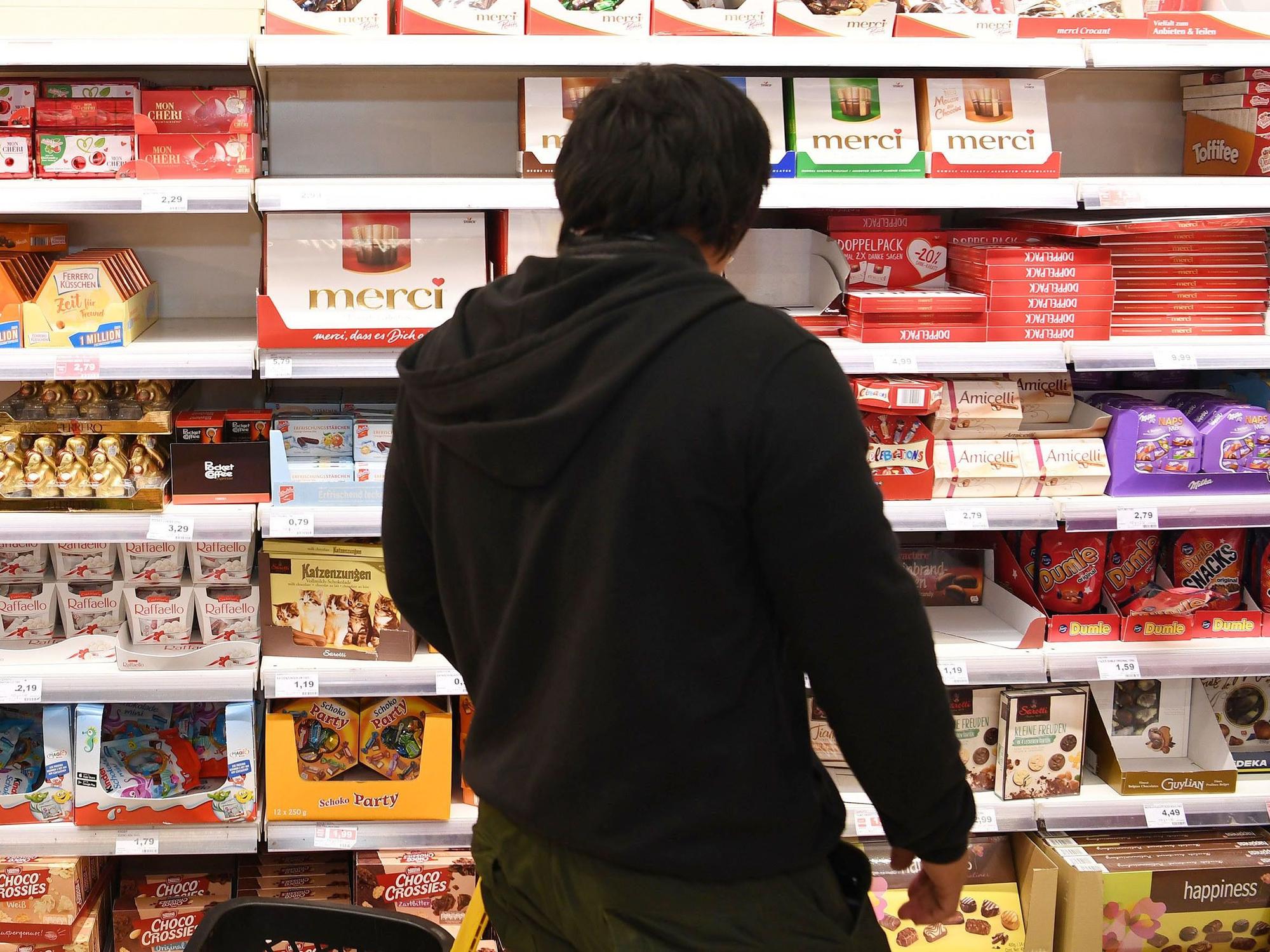 Ein Mann, hier im Oktober 2018 in Bremerhaven, steht in einem Supermarkt vor einem Regal mit verschiedenen Schokoladenprodukten.