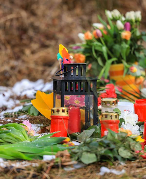 16.03.2023, Nordrhein-Westfalen, Freudenberg: Kerzen und Blumen liegen in einem Wald im südlichen Nordrhein-Westfalen.
