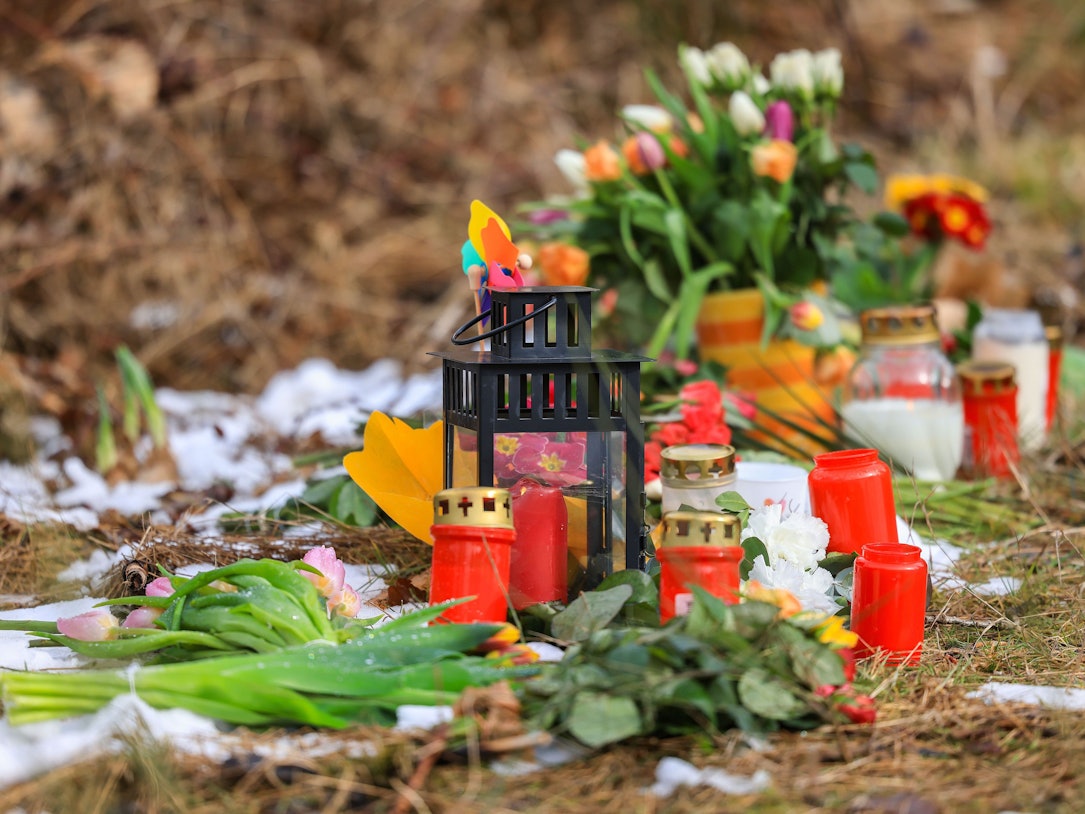 16.03.2023, Nordrhein-Westfalen, Freudenberg: Kerzen und Blumen liegen in einem Wald im südlichen Nordrhein-Westfalen.