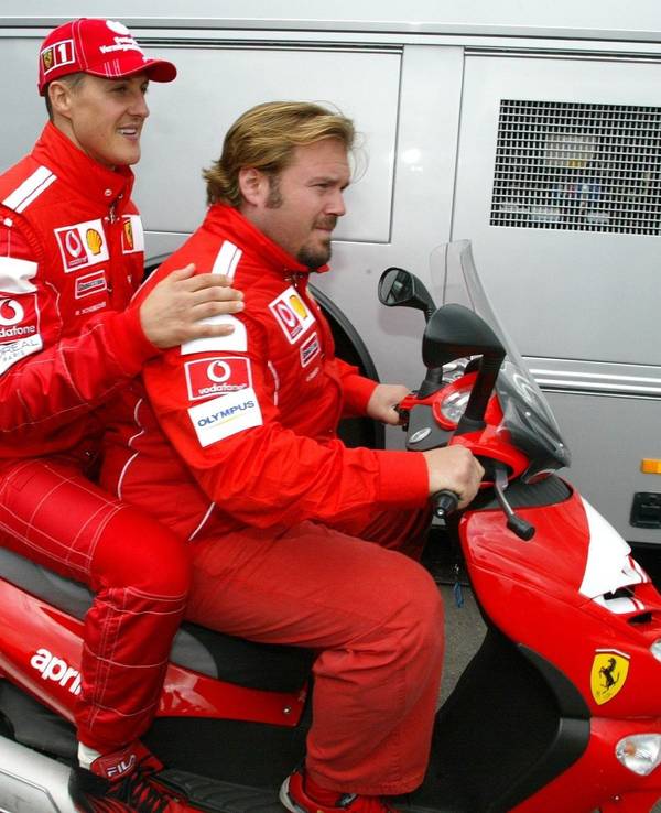 Michael Schumacher und Gino Rosato fahren auf einem Motorroller.