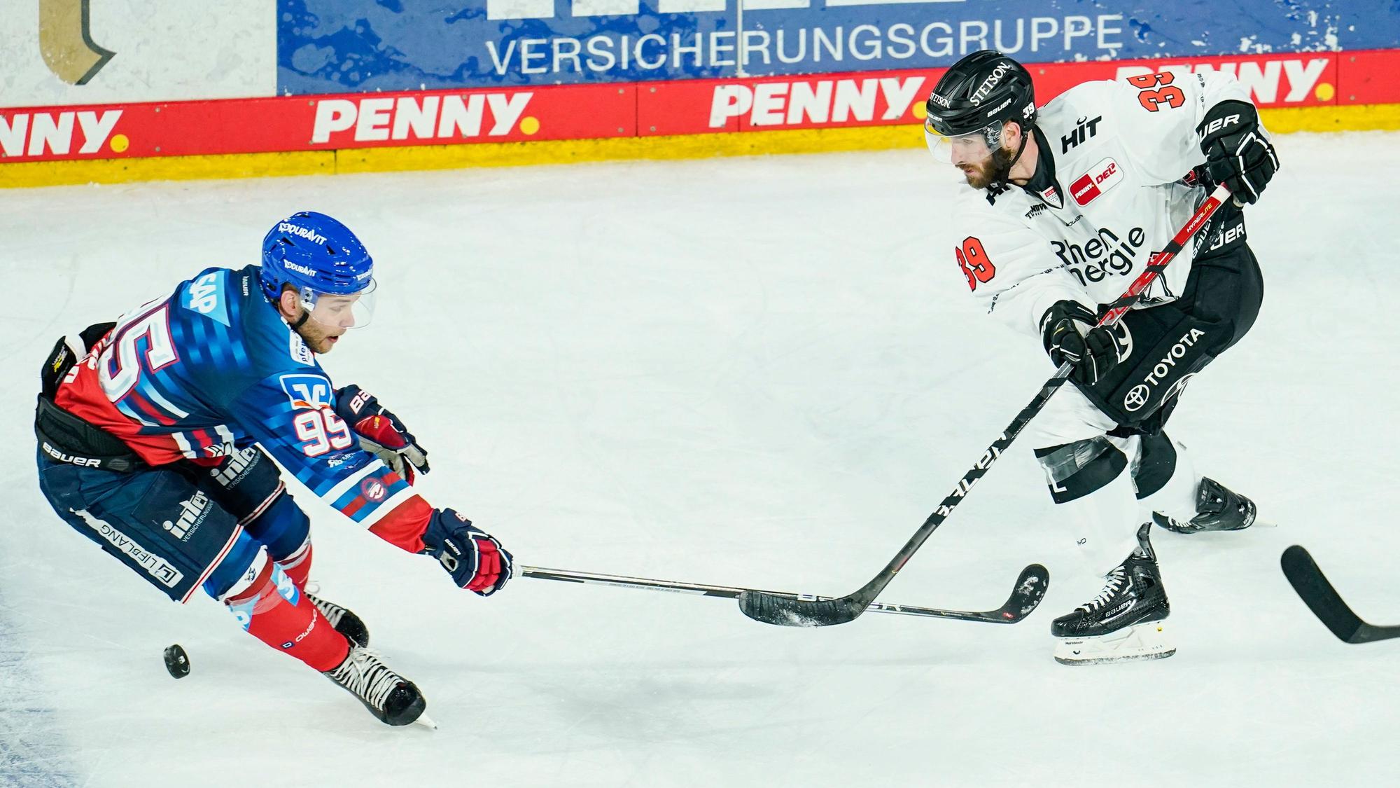 Mannheims Mark Katic (l) und Kölns Landon Ferraro kämpfen um den Puck.