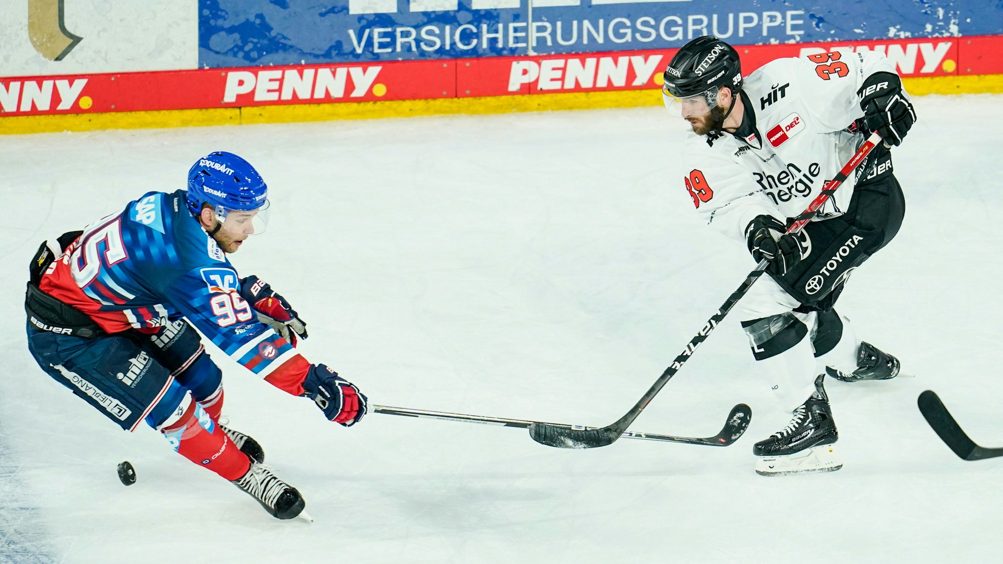 Mannheims Mark Katic (l) und Kölns Landon Ferraro kämpfen um den Puck.