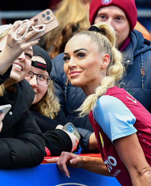 Alisha Lehmann posiert mit Fans für ein Selfie.