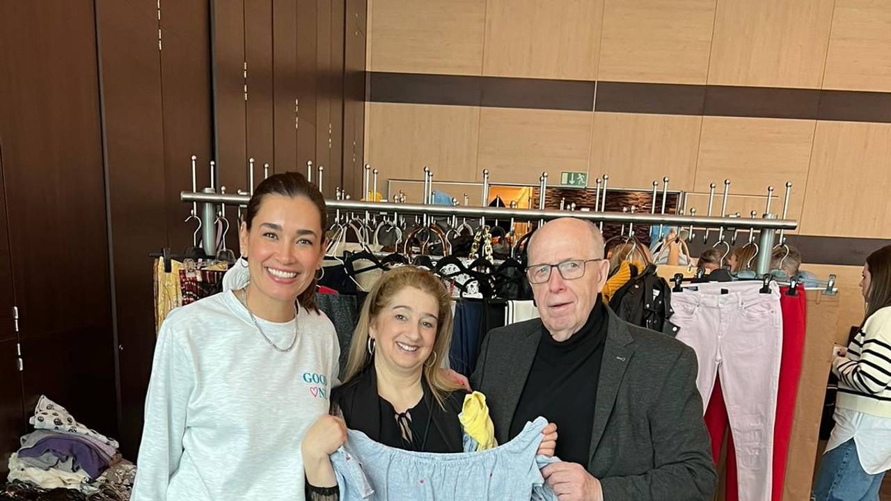 Jana Ina Zarrella lächelt auf einer Veranstaltung mit Reiner Calmund in die Kamera.