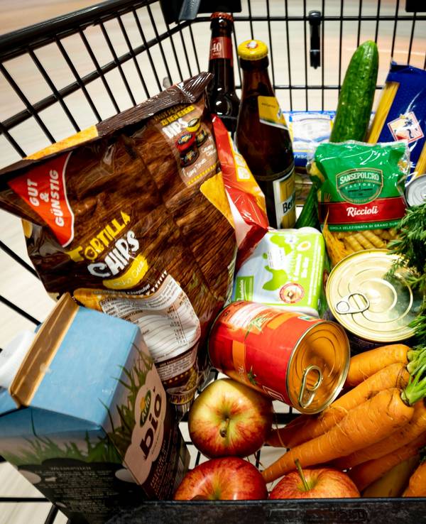 Lebensmittel liegen in einem Einkaufswagen in einem Supermarkt.