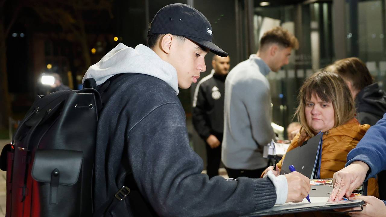 Jamal Musiala (l) und Leon Goretzka geben wartenden Fans bei der Anreise des Kaders ins Frankfurter Teamhotel, dem Hotel Melia Frankfurt City, Autogramme.