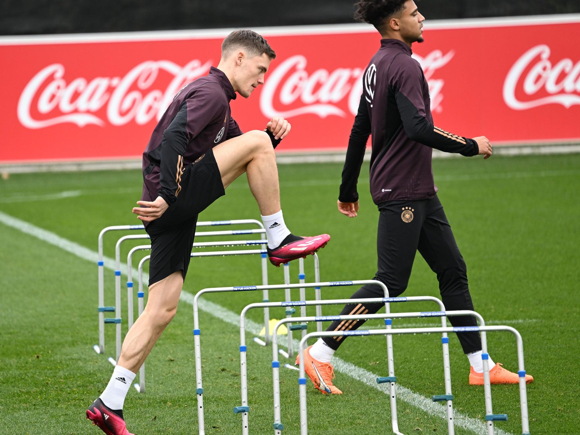 Die Spieler Florian Wirtz (l) und Kevin Schade sind beim Training der Nationalmannschaft auf dem Trainingsplatz des DFB-Campus in Aktion.