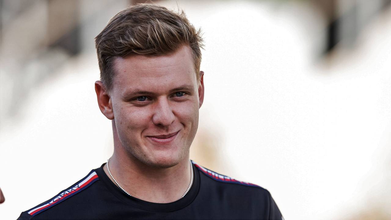 Mick Schumacher grinst beim Gang durch das Fahrerlager der Formel 1.