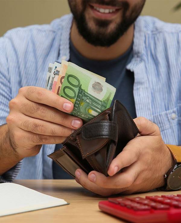 Mann zieht Euro Geldscheine aus der Geldbörse.