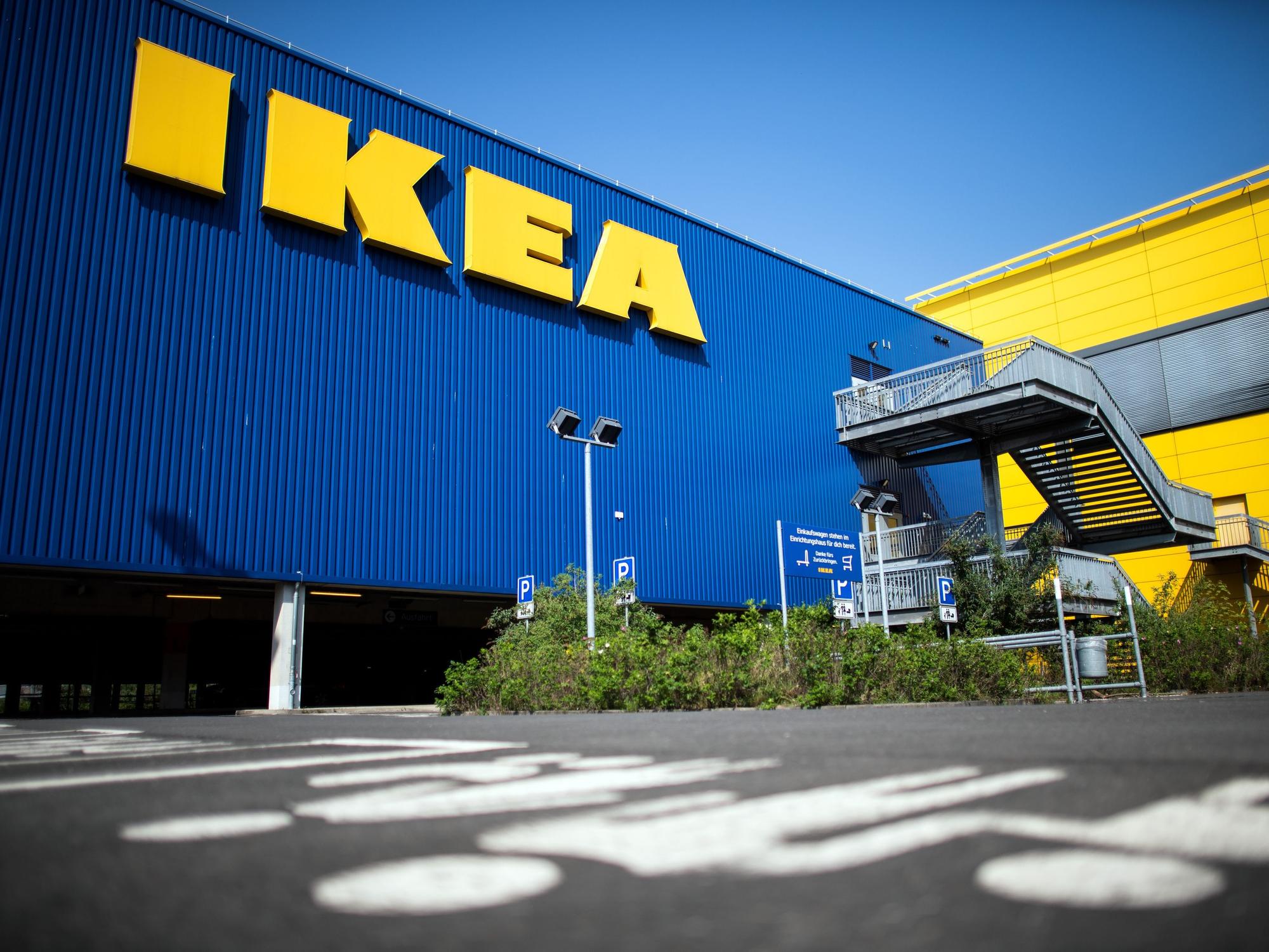 Die Fassade einer IKEA-Filiale in Köln mit dem großen IKEA-Schriftzug, hier im April 2020. Piktogramme am Boden weißen auf die Familienparkplätze bei einem Ikea-Einrichtungshaus hin.