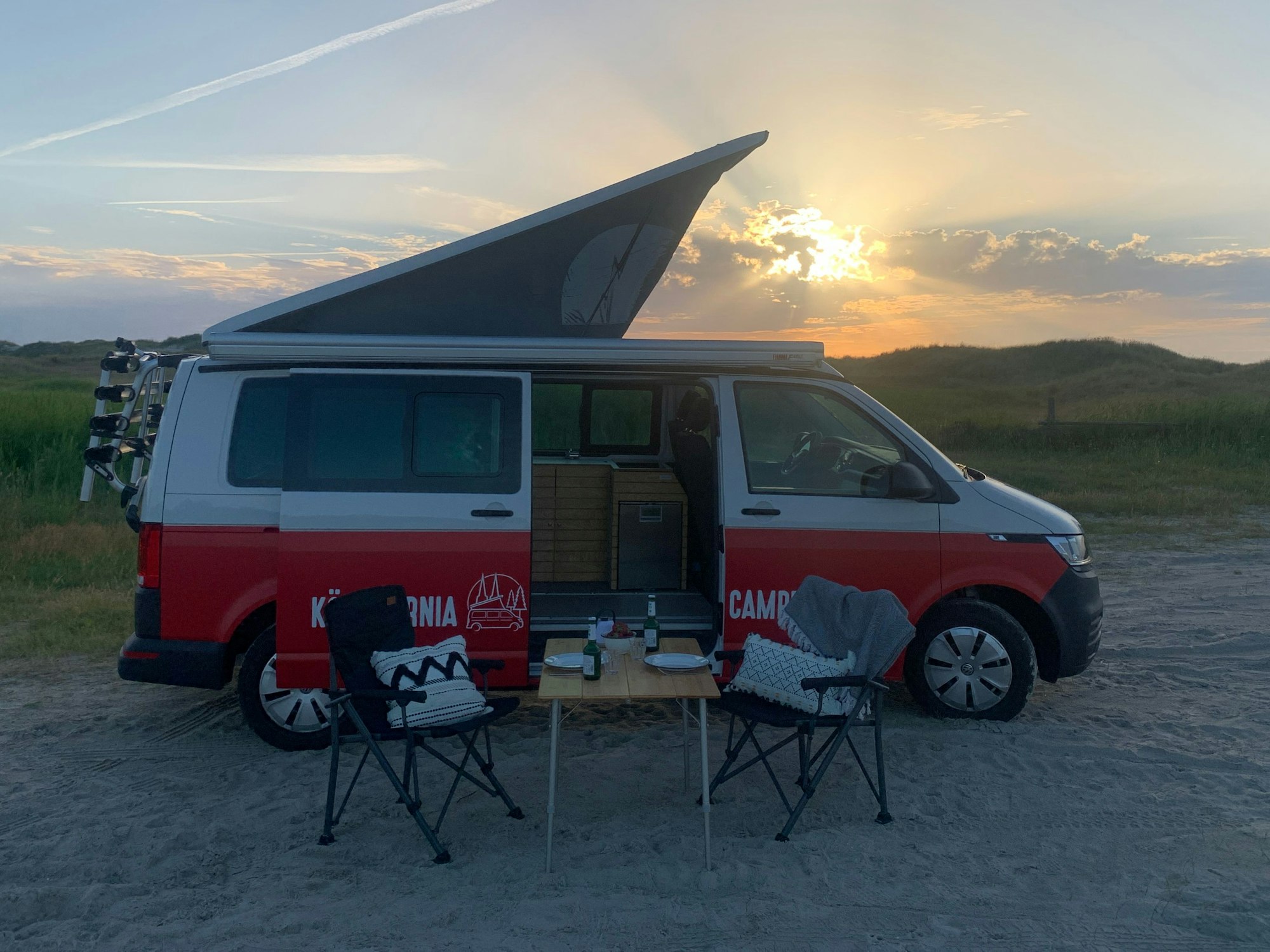 EIn Foto von einem Camper vor dem Sonnenunterang.