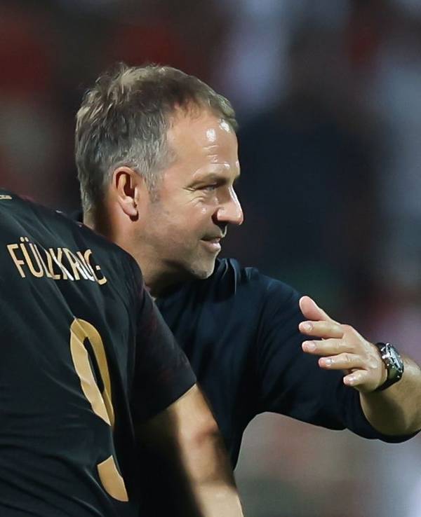 Niclas Füllkrug geht zufrieden am Bundestrainer Hansi Flick vorbei. Flick klopft Füllkrug auf den Rücken.