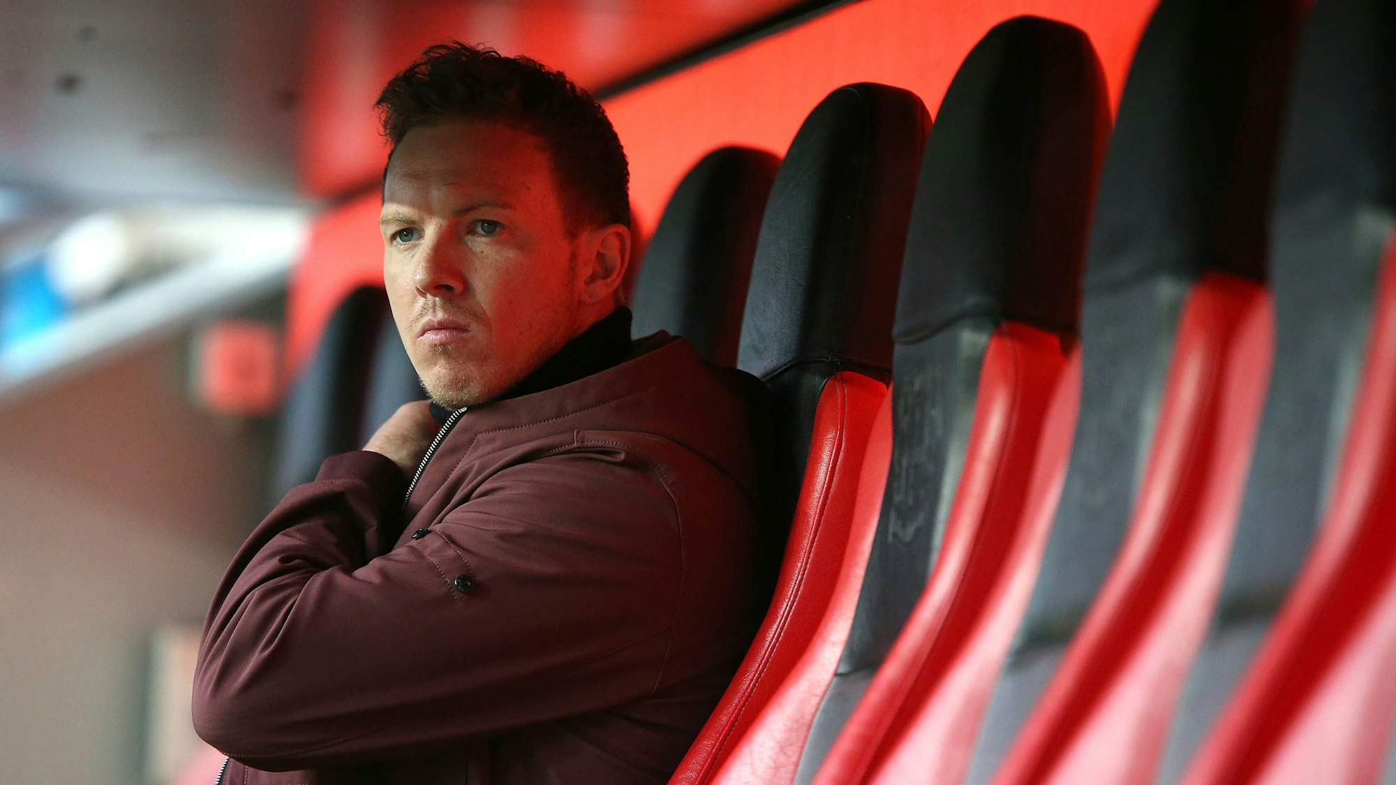 Bayern Münchens Trainer Julian Nagelsmann sitzt in der BayArena in Leverkusen auf der Trainerbank und schaut auf das Spielfeld.
