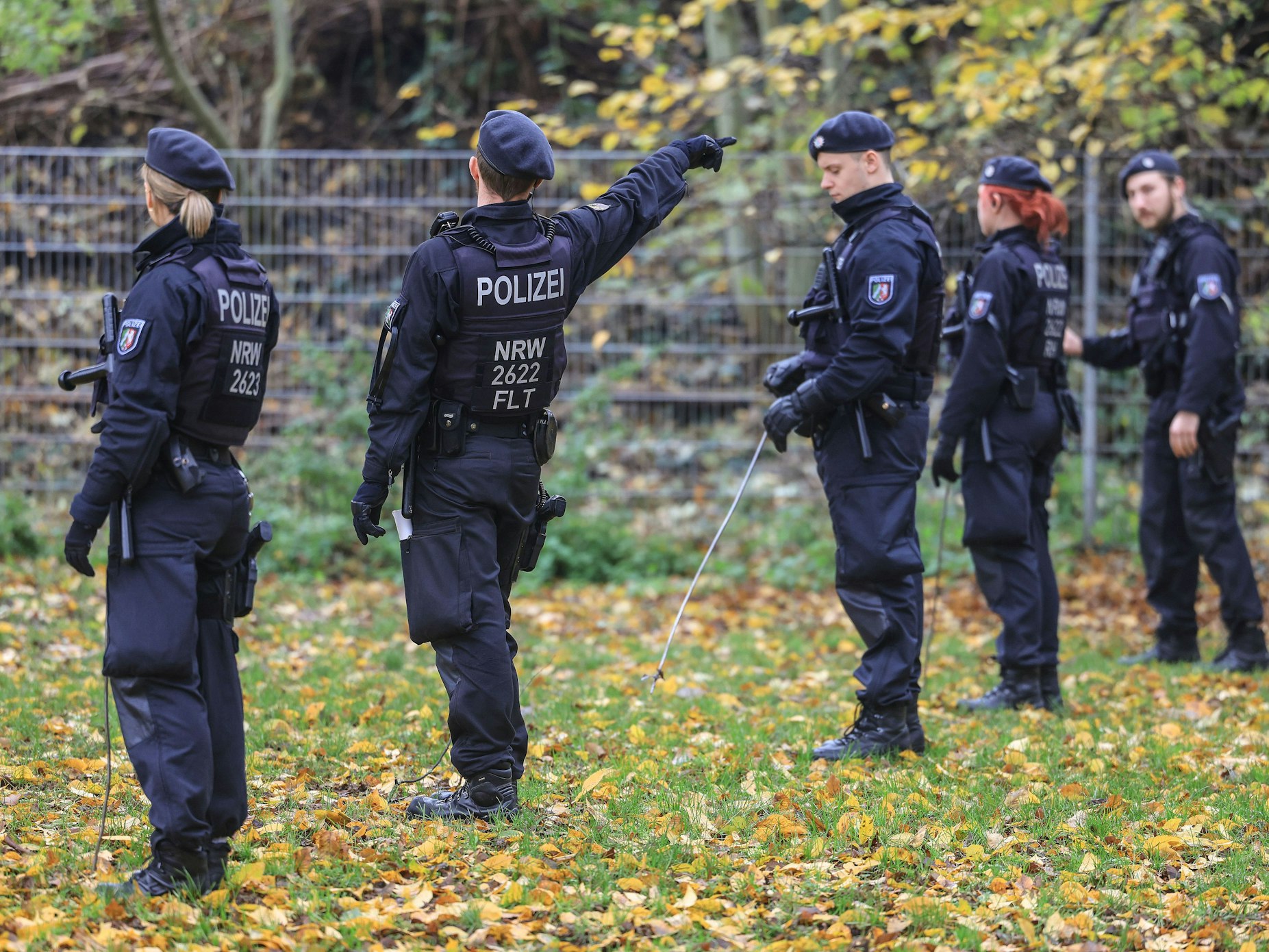 Polizisten suchen mit Eisenstangen, hier im November 2022 in Krefeld, eine Wiese ab.