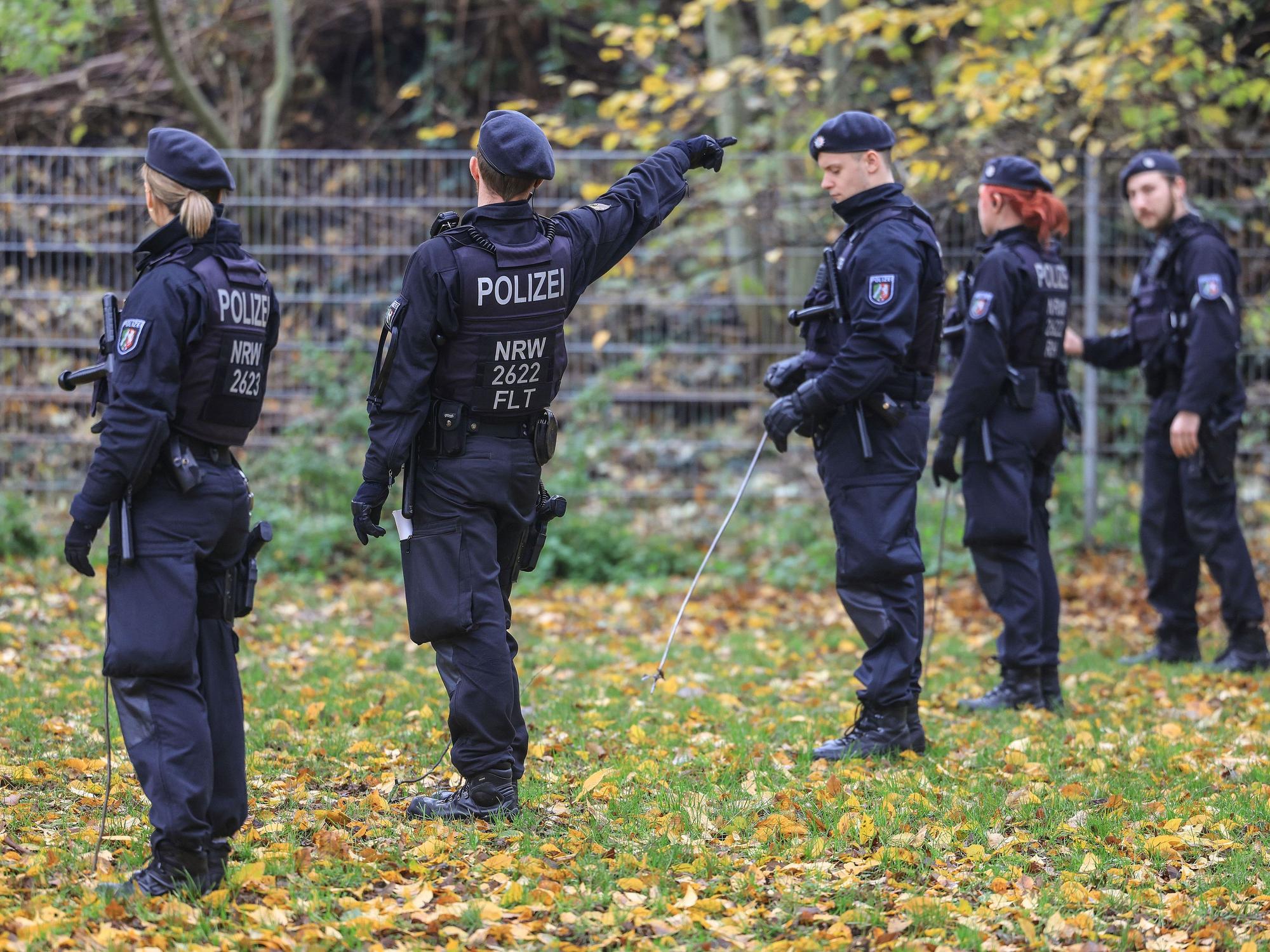 Polizisten suchen mit Eisenstangen, hier im November 2022 in Krefeld, eine Wiese ab.