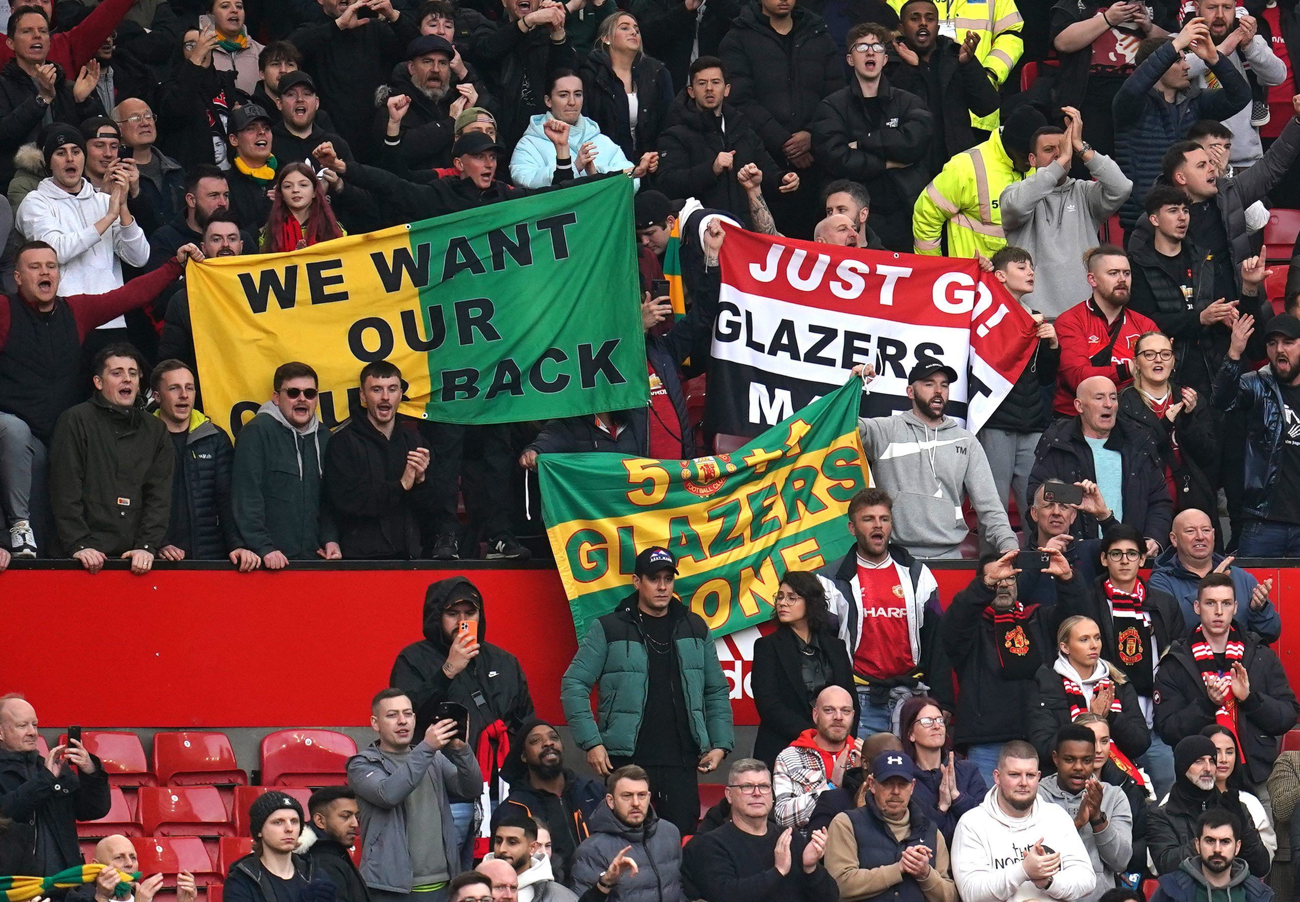 Fans auf der Tribüne halten Transparente hoch, um gegen die derzeitigen Eigentümer des Vereins, die Familie Glazer, zu demonstrieren.