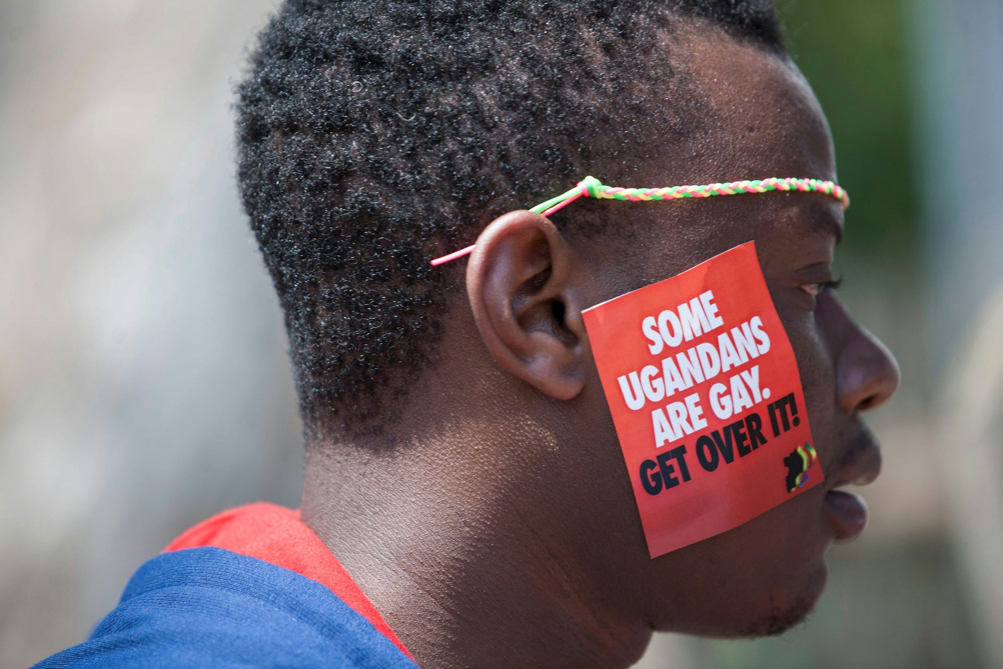 Uganda, Entebbe: Ein ugandischer Mann trägt einen Aufkleber mit der Aufschrift "Some Ugandans Are Gay. Get Over It" („Einige Ugander sind schwul. Finde dich damit ab“) während der LGBT-Pride-Feierlichkeiten auf seiner Wange. Symbolfoto vom 08.08.2014.
