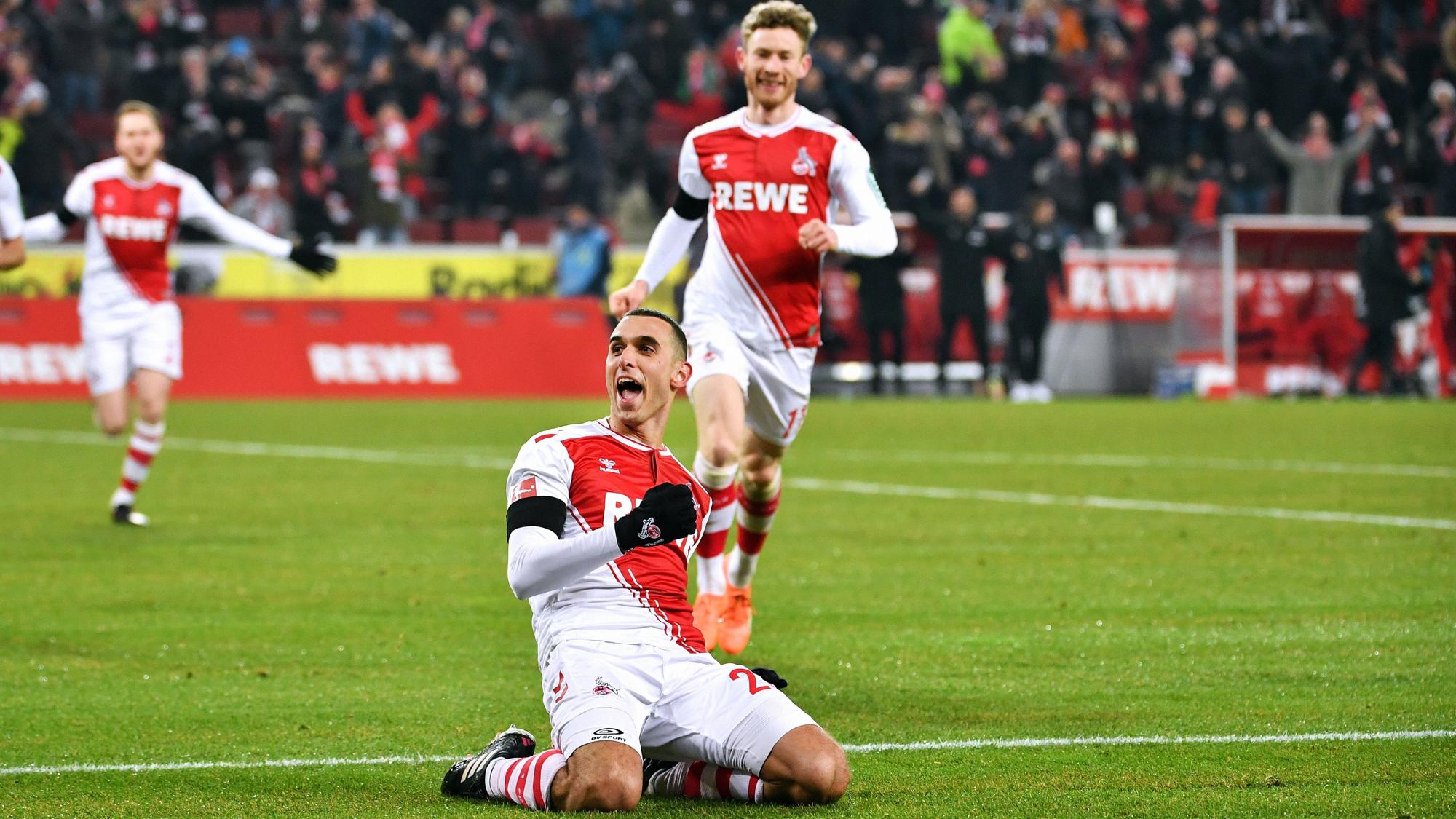 Ellyes Skhiri bejubelt auf Knien rutschend ein Tor für den 1. FC Köln, hinter ihm kommt Florian Kainz dazu.