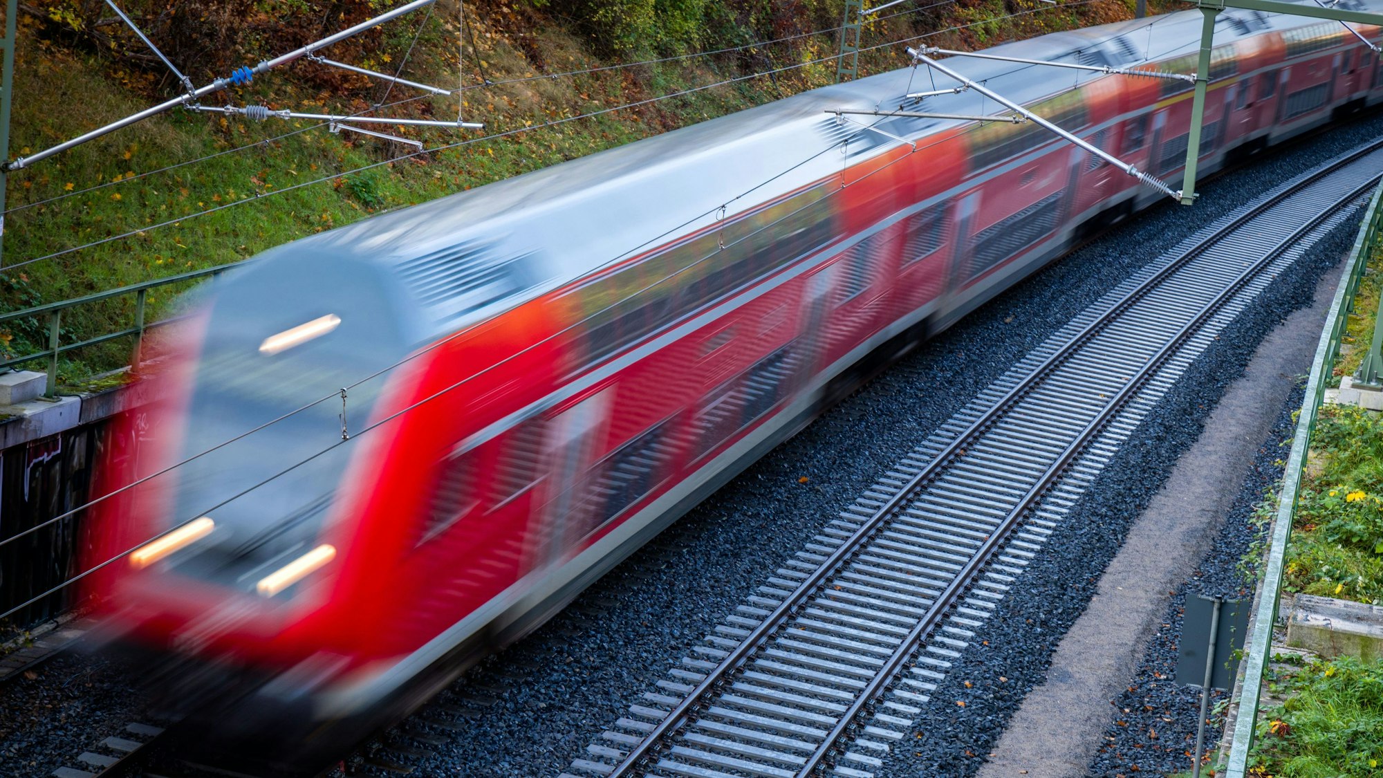 Hier zu sehen, ein Zug der Deutschen Bahn fährt über Bahngleise.