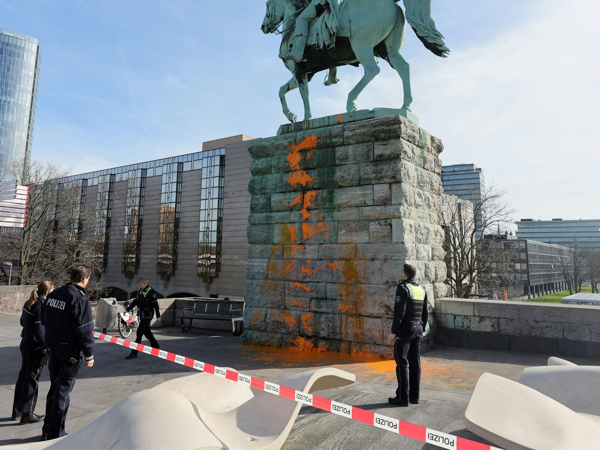 Einsatzkräfte der Polizei begutachten am 16. März 2023 die Farbattacke am Reiterdenkmal an der Hohenzollernbrücke.