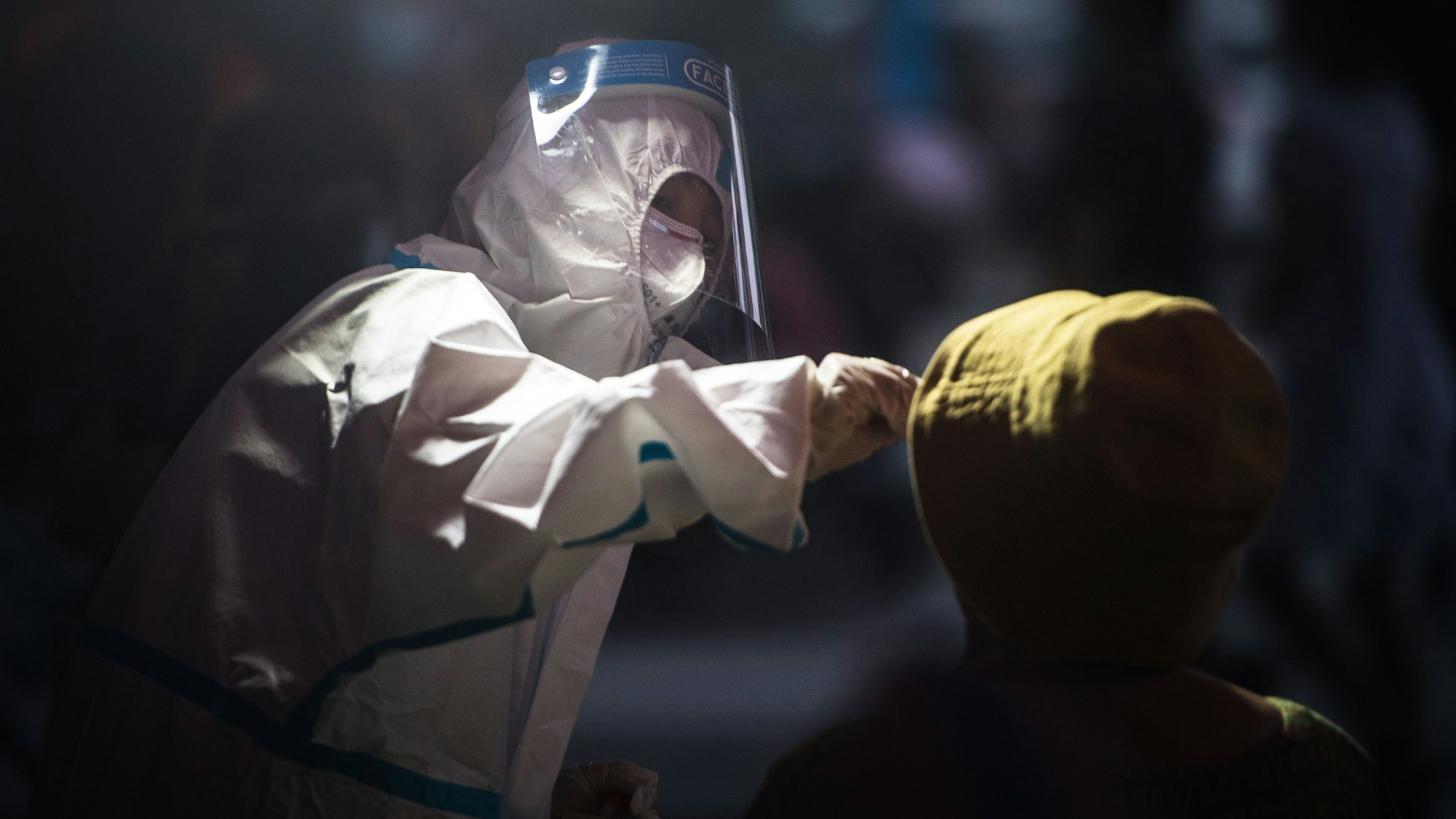 Ein medizinischer Mitarbeiter entnimmt in unserem Archivbild (2021) einem Einwohner von Wuhan eine Abstrichprobe für einen Corona-Test.