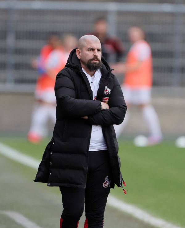 Sascha Glass steht beim Spiel der Frauen des 1. FC Köln gegen den FC Bayern München mit verschränkten Armen an der Seitenlinie.