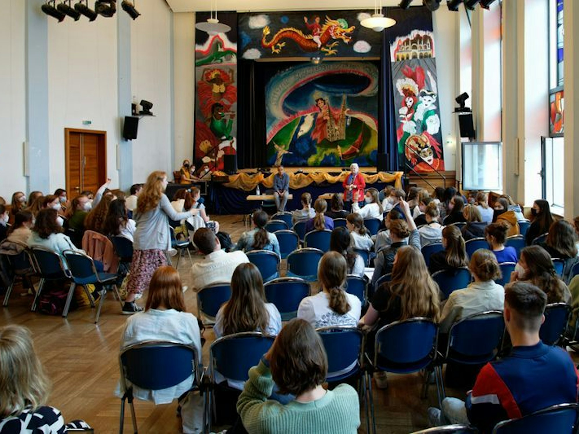 Schülerinnen sitzen in einer Raum.