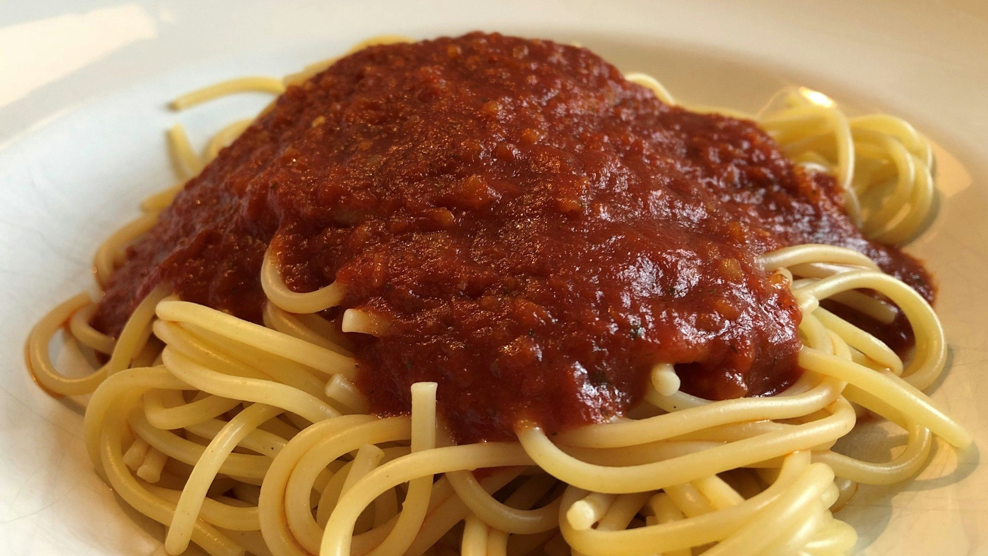 Das Symbolfoto aus dem Jahr 2021 zeigt einen hellen Teller mit einer Portion Spaghetti mit Tomatensoße.