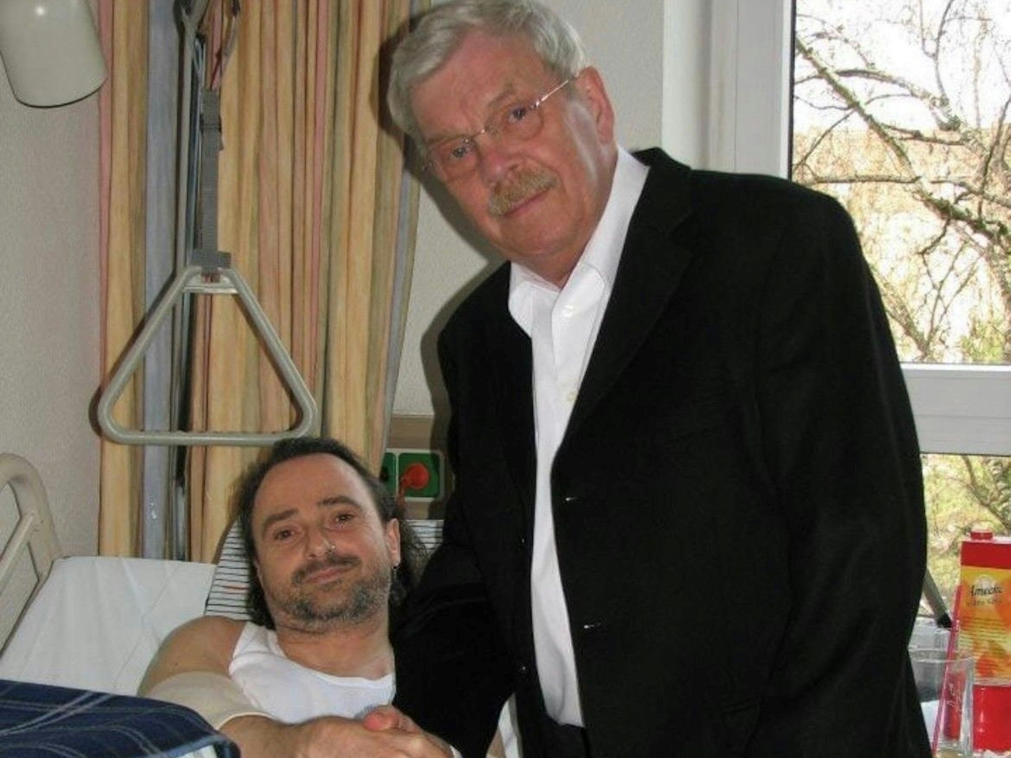 Ein Mann liegt in einem Krankenhausbett.
