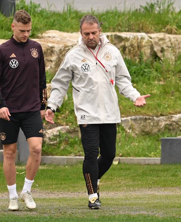 Joshua Kimmich (l) und Bundestrainer Hansi Flick kommen zum Training der deutschen Nationalmannschaft auf den Trainingsplatz des DFB-Campus.