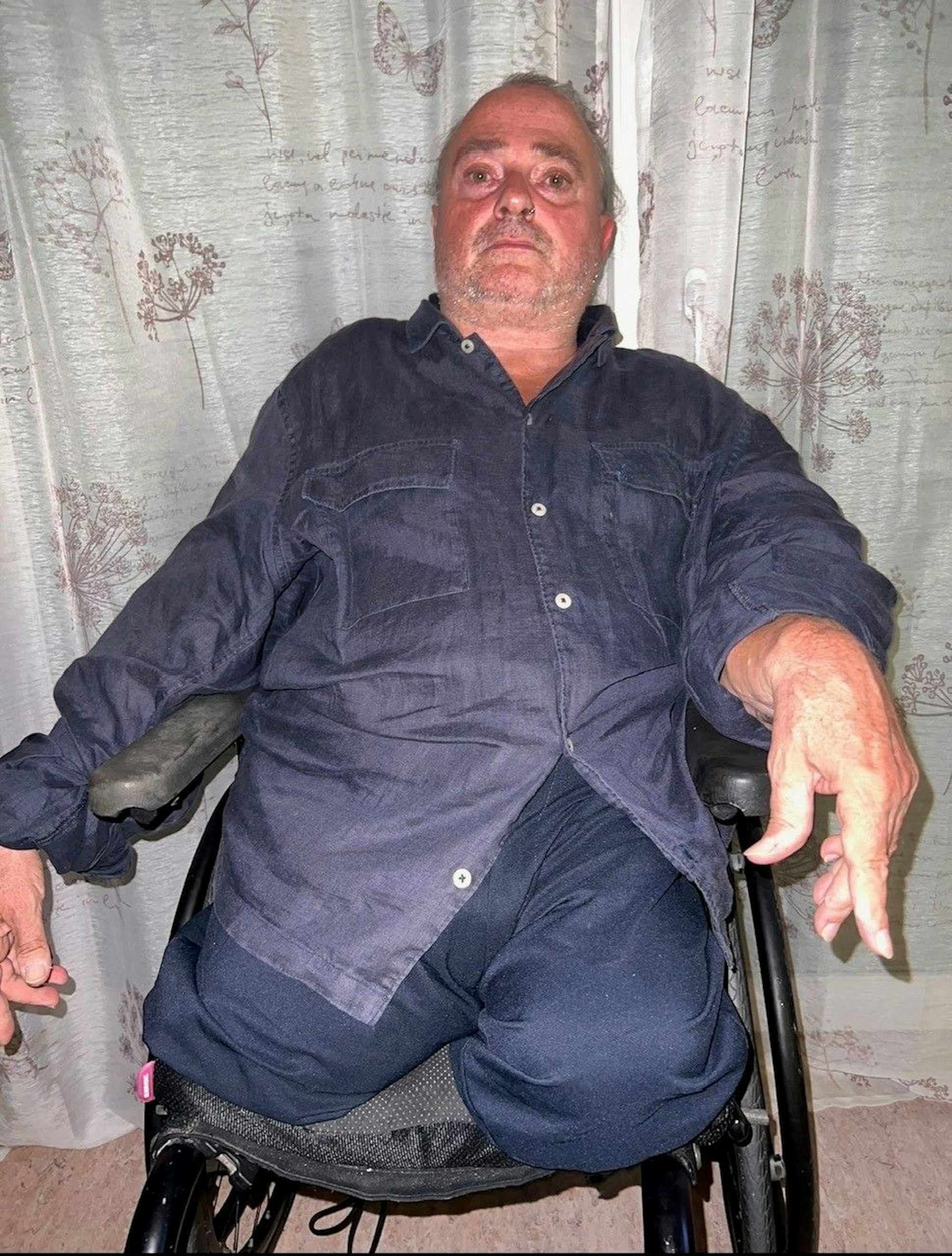 Ein Mann sitzt in einem Rollstuhl.